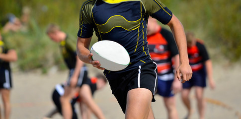 Playing rugby at the beach. Team sport