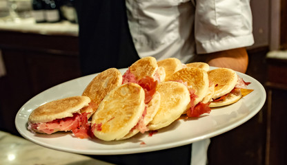 Tigelle con prosciutto crudo, aperitivo al bar, fuoco selettivo