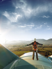 Happy engineer feel success after good work. He standing a top of windmill and looking beautiful...