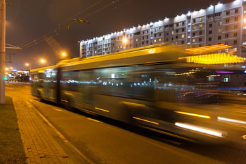 Fototapeta na wymiar The motion of a blurred trolleybus in the street in the evening.