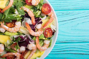 Mix of salad with shrimps , avocado and cherry tomatoes . Healthy food background