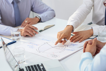 Cropped image of business team discussing diagram at meeting