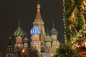 Fototapeta na wymiar Moscow, Russia, December 4, 2018. View of the domes of St. Basil’s Cathedral and New Year’s decorations on trees in Red Square in the evening city