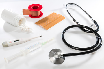 stethoscope on white table with syringe