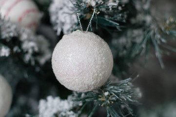 Festive Christmas background gray New Year's ball and snow on a Christmas tree