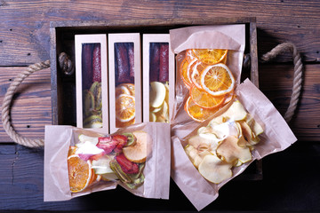 Assorted dried fruits in wooden box, oranges, apples, kiwi, strawberry