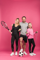 sporty family with sport equipment on pink