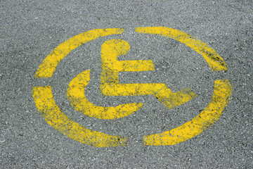 Fototapeta premium Disabled persons no parking sign yellow on grey asphalt 