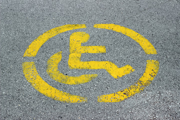 Fototapeta premium Disabled persons no parking sign yellow on grey asphalt 