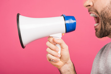 cropped view of angry man screaming with megaphone, isolated on pink