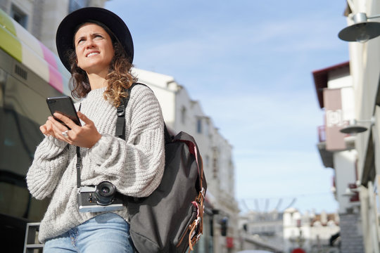 Brunette tourist looking for directions on cellphone in city