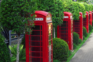 Traditional old style UK red phone box in garden