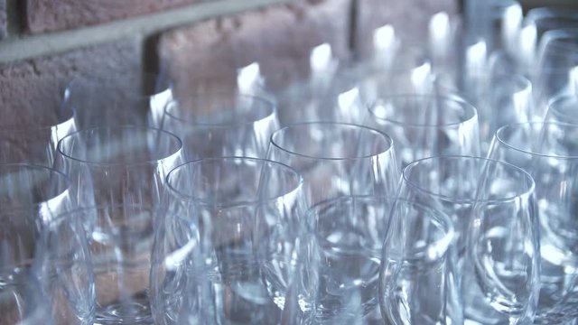 rows of empty glass goblets on a brick wall background