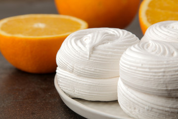 Sweet white round marshmallow with oranges close-up on a brown wooden table. Sweets. dessert.