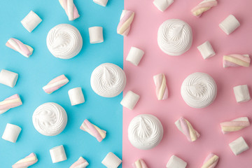 Background of sweet white marshmallows and small marshmallows on a bright trendy pink and blue background. Sweets. dessert. view from above