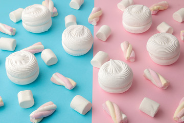 Background of sweet white marshmallows and small marshmallows on a bright trendy pink and blue background. Sweets. dessert.