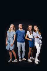 Group of young people in denim clothes on a black background