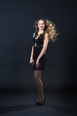 Fototapeta na wymiar Portrait of a smiling young girl in a lace dress on a black background