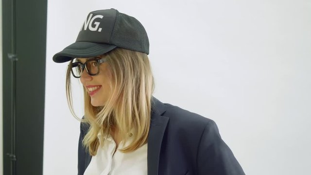 Model in black baseball cap and balck jacket poses during photoshoot