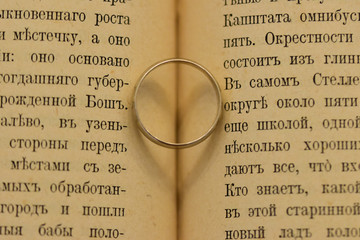 Engagement ring in a book with a heart-shaped shadow
