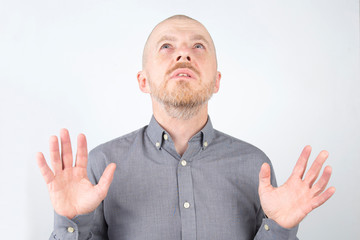 Fototapeta premium Bearded man with raised hands looking up
