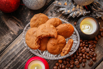 Cookies filled with chocolate, Christmas balls, candles and coffee beans. Close-up on the old rustic wooden table
