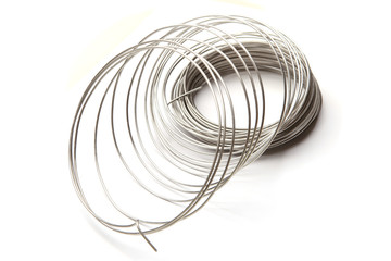 Coil of stainless steel wire isolated on white background.  Stack of stainless steel metal wire.