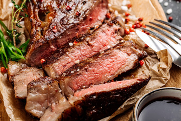 Beef rump steak from marble beef medium rare with sauce on wood plate, close-up. Selective focus.