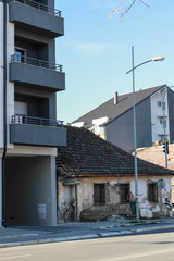 Old ruined house near modern buildings