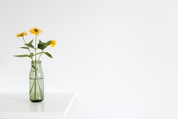 Bouquet of spring flowers in a vase on a table. Bright interior mock up.