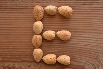 the letter E shaped with almonds on wood