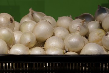 a bunch of white onions in a black box