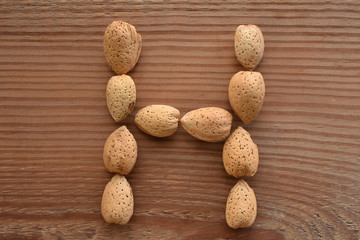 the letter H shaped with almonds on wood
