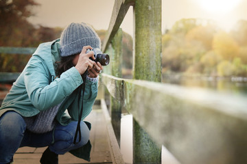 Attractive brunette taking photos outdoors in fall