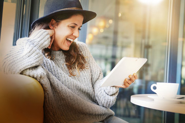 Attractive brunette with tablet in modern cafe
