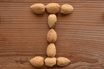 the letter I shaped with almonds on wood