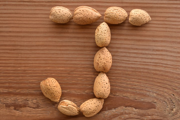 the letter J shaped with almonds on wood