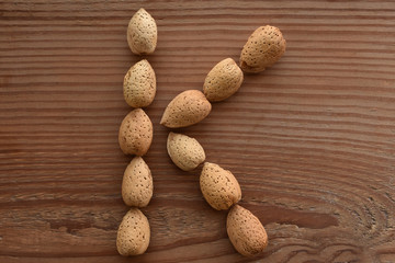 the letter K shaped with almonds on wood