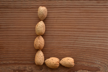the letter L shaped with almonds on wood