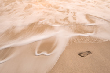 sea wave move to erase human footprint on beach