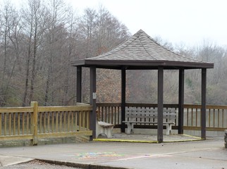 The brown wooden gazebo seating area on a misty day.