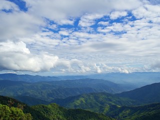 Fototapeta premium Landscape of afternoon green mountain and bluesky with cloud in viewpoint of Doi Phu Ka, Nan, Thailand