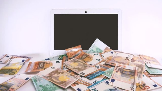 Slow motion of euro banknotes pouring over a laptop. E-comerce, online shopping, Black Friday, holidays, Christmas money spending concept