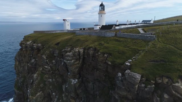 Rising drone shot of Dunnet Head lighthouse built on a spectacular cliff top in the highlands of Scotland
