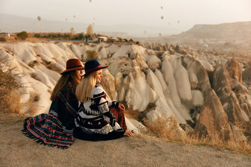 Travel. Women Looking At Flying Hot Air Balloons In Sky