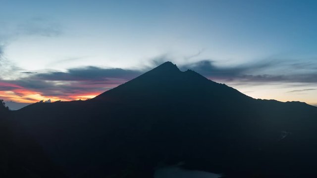 Sunrise at Mount Rinjani Volcano on Lombok Indonesia 4K time-lapse. Clouds are forming at the top of the mountain during golden hour