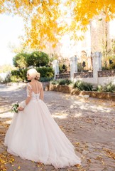 Beautiful blonde bride in white dress in the garden