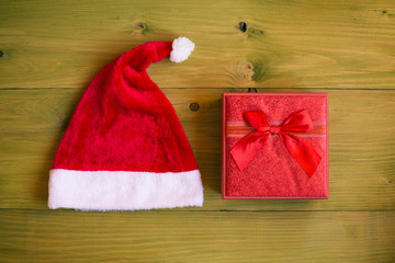 Obraz na płótnie Canvas Image of Santa Hat and gift on wooden table.