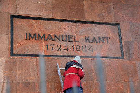 A handyman in uniform on the stairs washes the grave of the philosopher Immanuel Kant after an act of vandalism. Kaliningrad, Russia