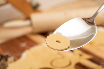 Kuchenbesteck mit rohem Keks und Nudelholz im Hintergrund